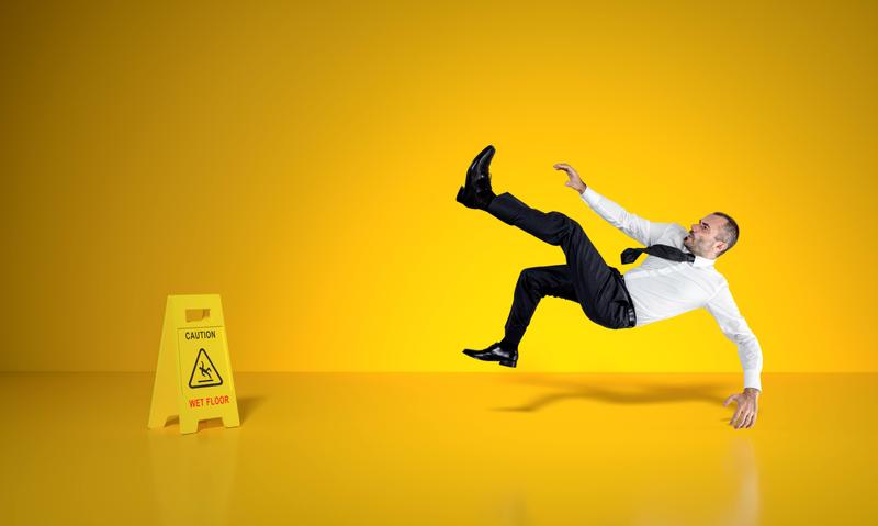 Person slipping in front of a wet floor sign